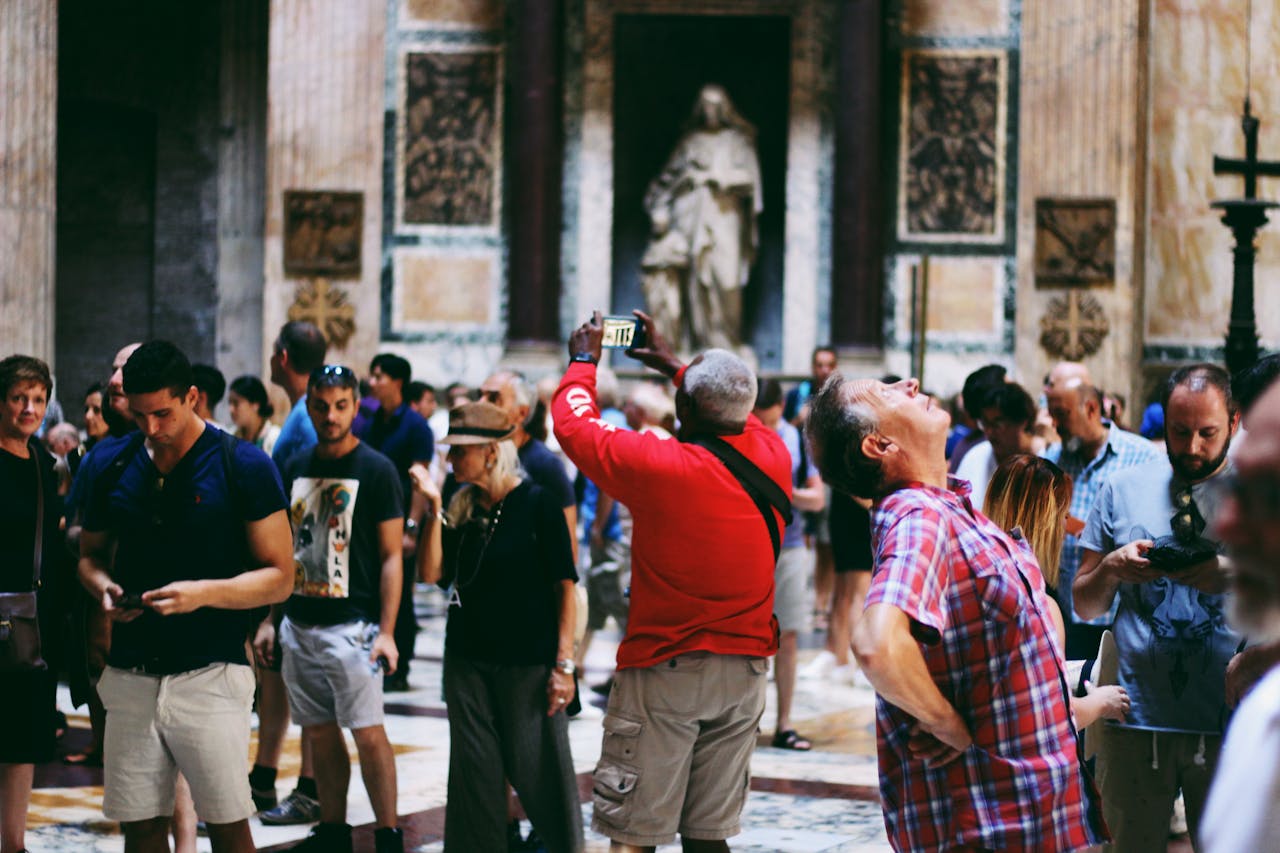 A crowd of tourists inside a historic building, capturing the architecture and art around them.