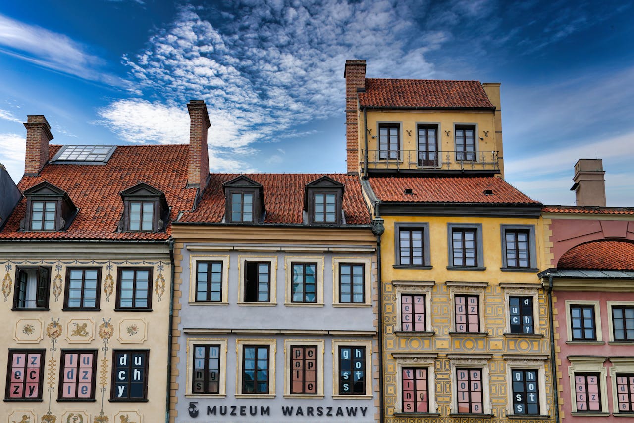 services-03 Colorful facades of historic buildings in Warsaw, Poland, under a vibrant blue sky.